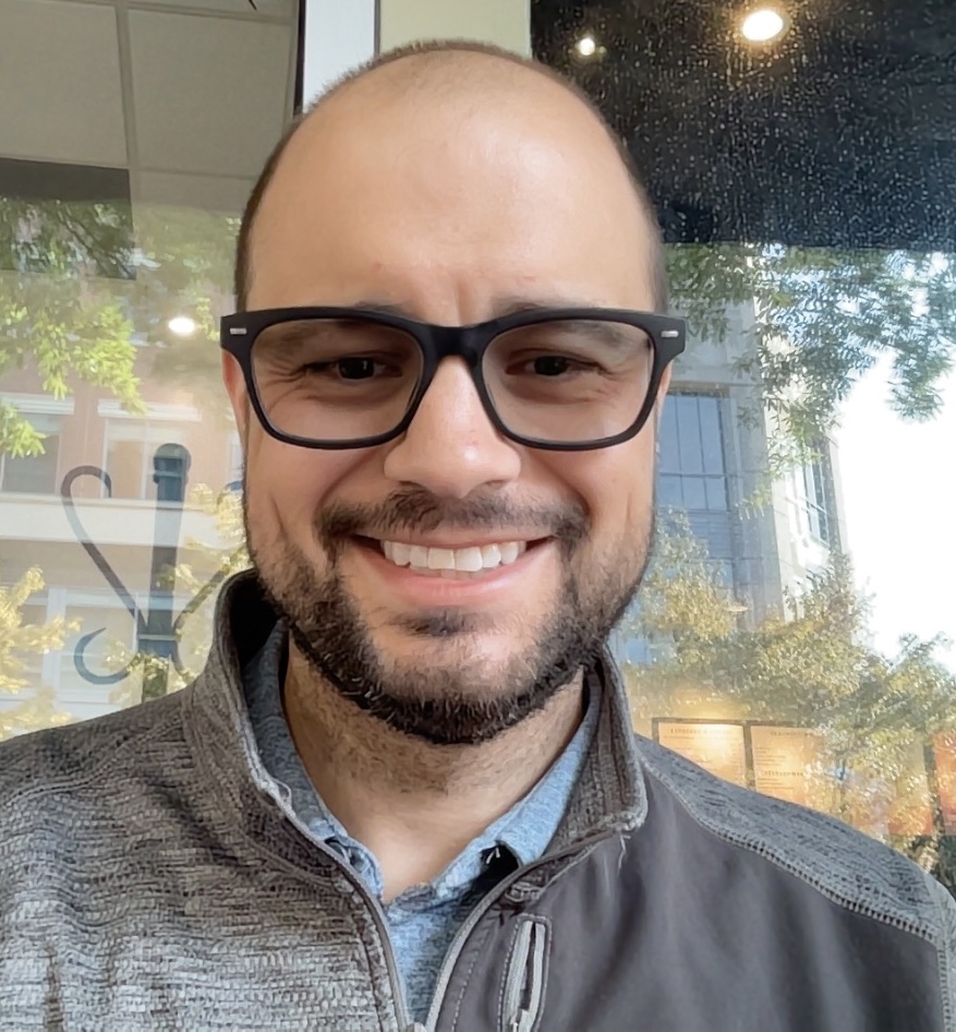 Kyle MacRitchie smiling, wearing glasses